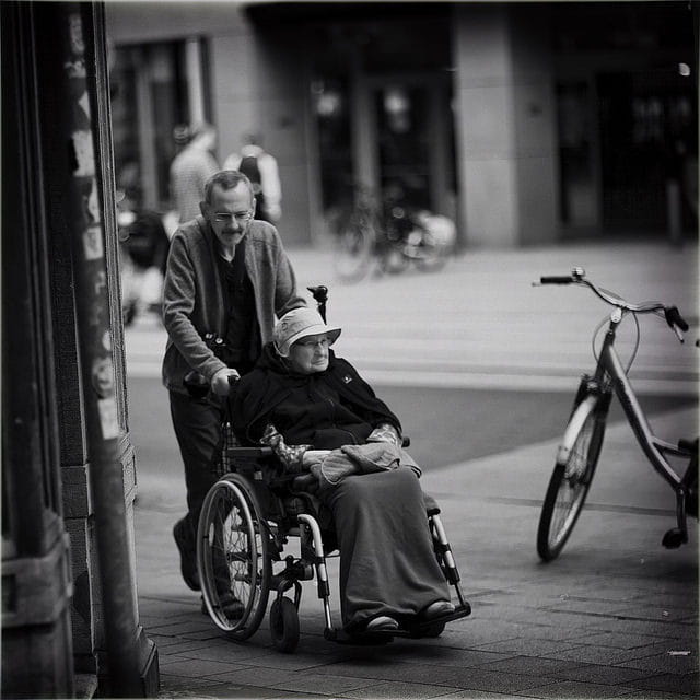 Personnes âgées dont une en chaise roulante.