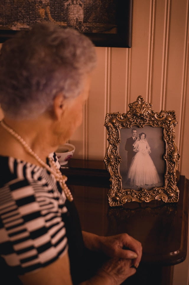 Personne âgée qui regarde sa photo de mariage.